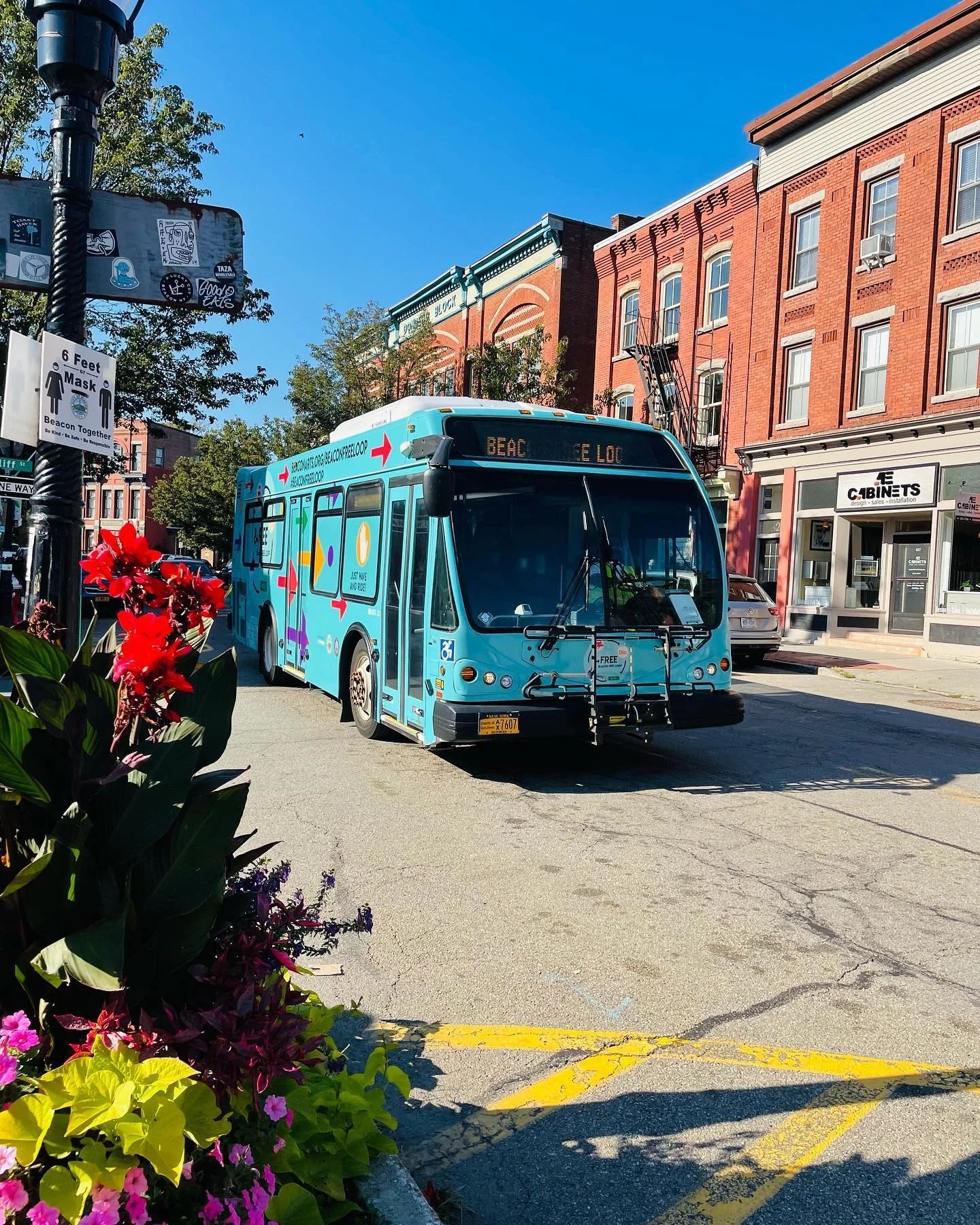 A blue bus with the number 410 on the front is driving down a city street