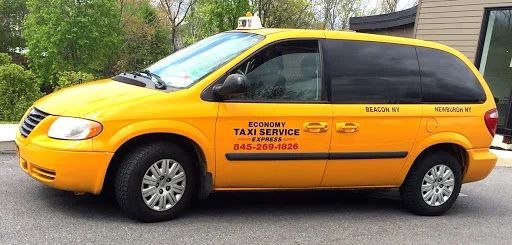 A yellow taxi is parked in front of a building.