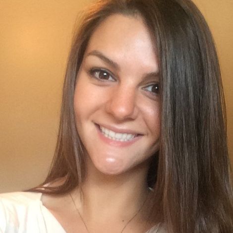 A woman with long hair is smiling and wearing a white shirt