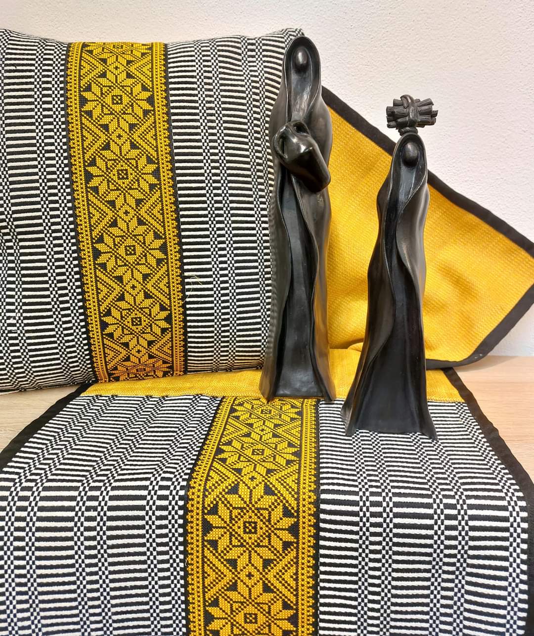 Un runner da tavolo nero e giallo con due statue sopra