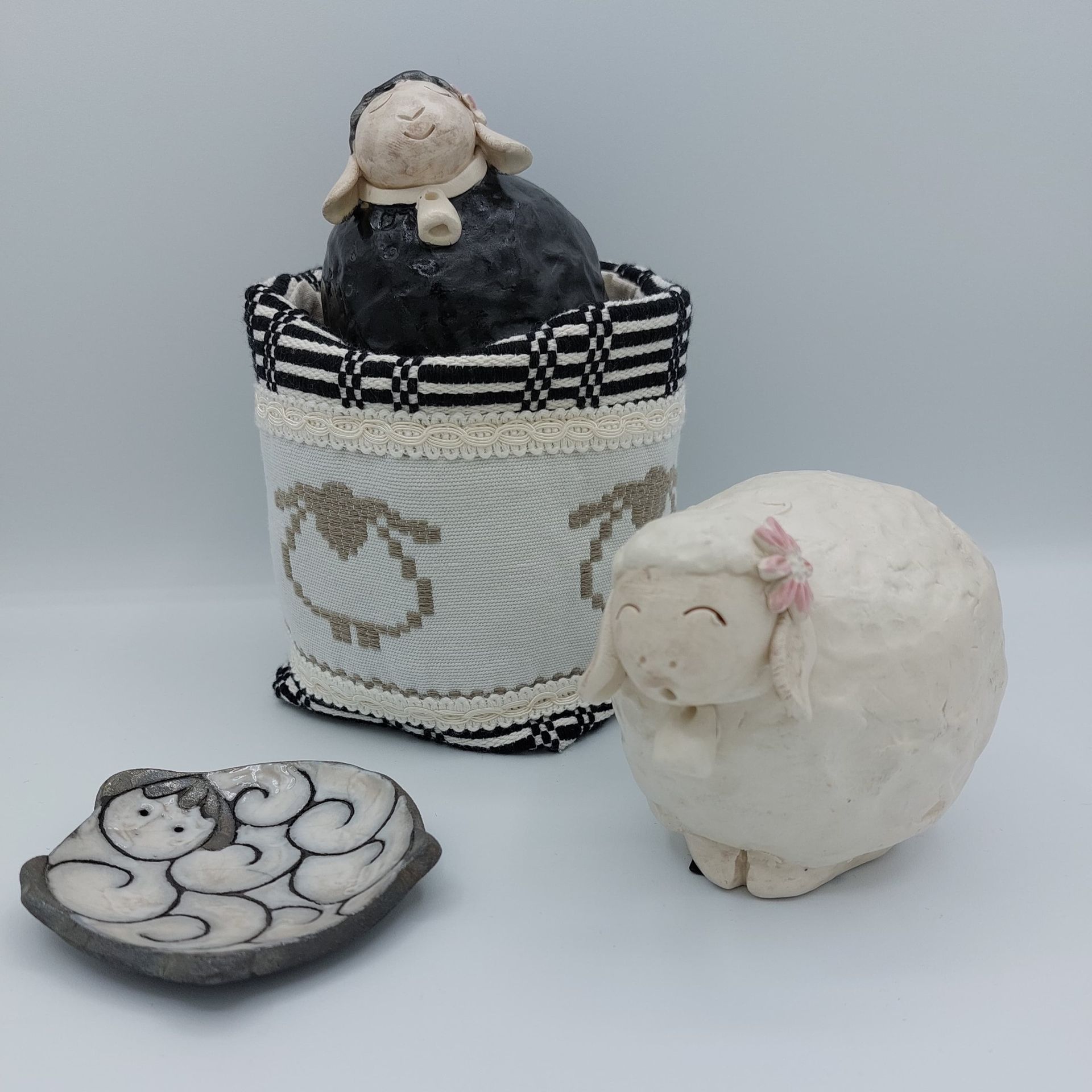 Due pecore in ceramica sono sedute una accanto all'altra su un tavolo