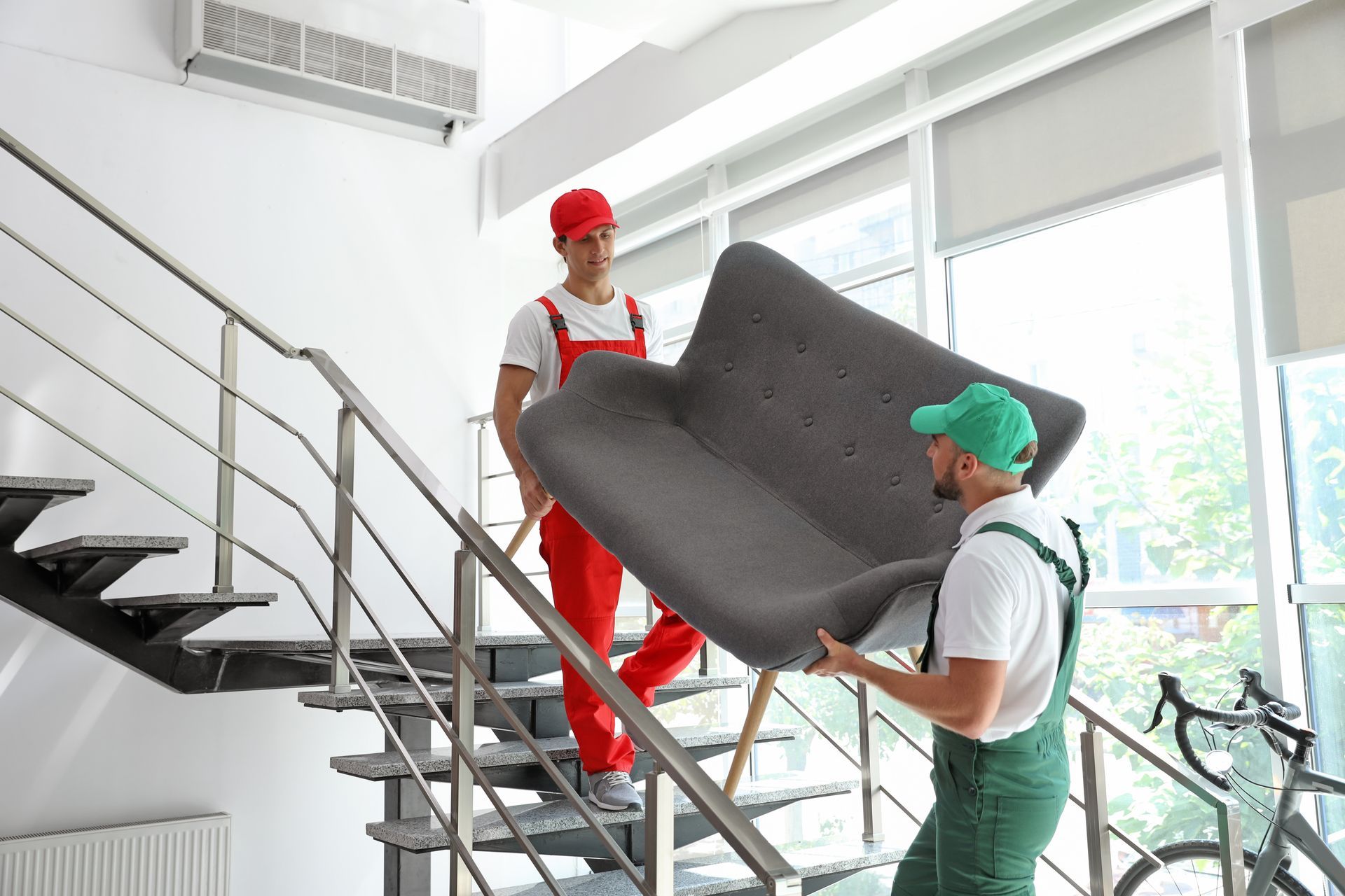 Two movers hold a sofa as they prepare for a move, showcasing expert moving company services.