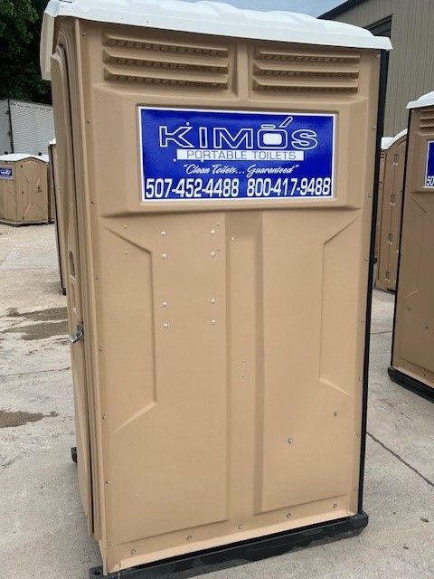 A man is lifting a portable toilet out of a truck.