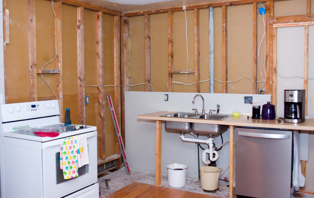 A kitchen under construction with a stove , sink , and dishwasher.