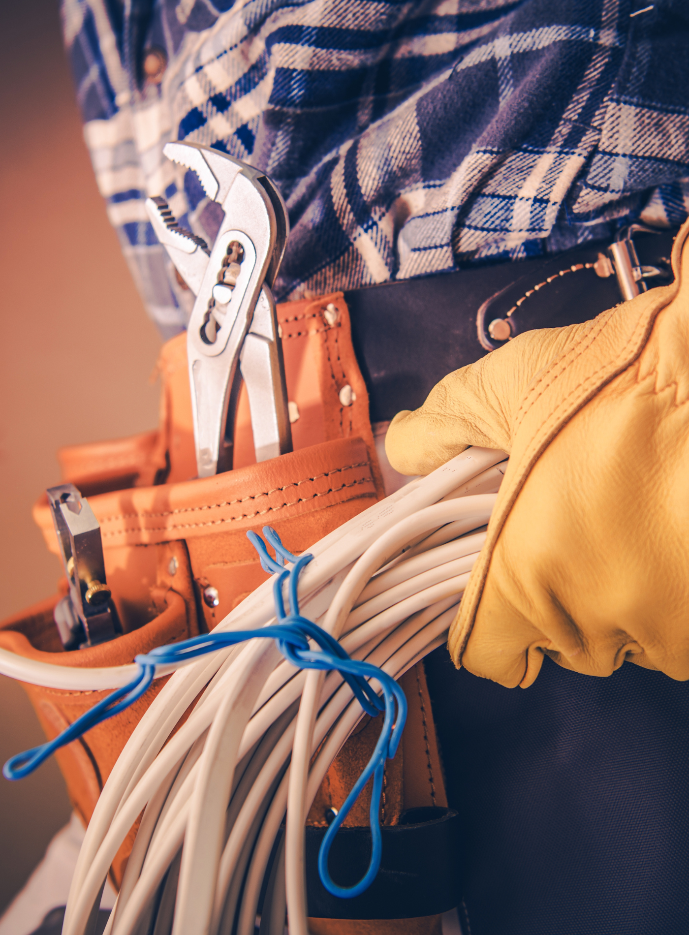 A man is holding a bunch of wires and a wrench.