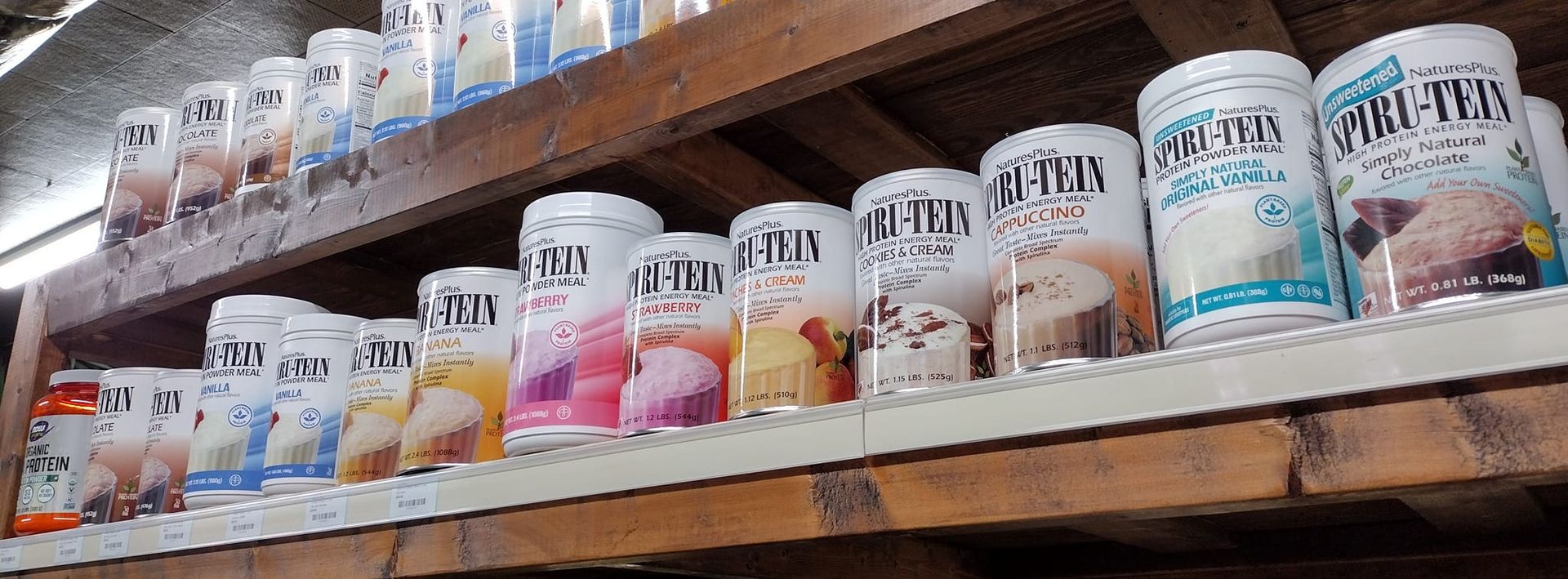 Shelves stocked with ice cream containers of various flavors, white and colorful.