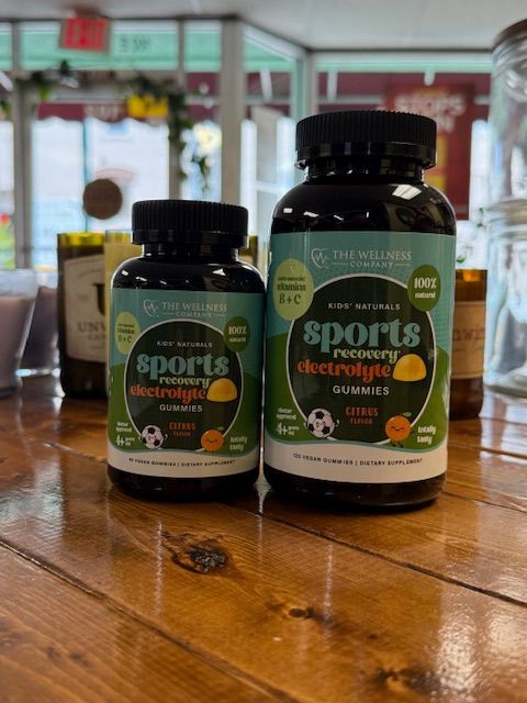 Two bottles of sports electrolyte gummies on a wooden surface in a store setting.