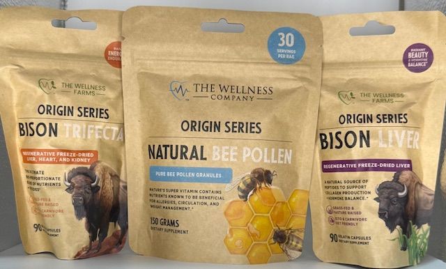 Three pouches of The Wellness Company supplements: Bison Trifecta, Bee Pollen, and Bison Liver.