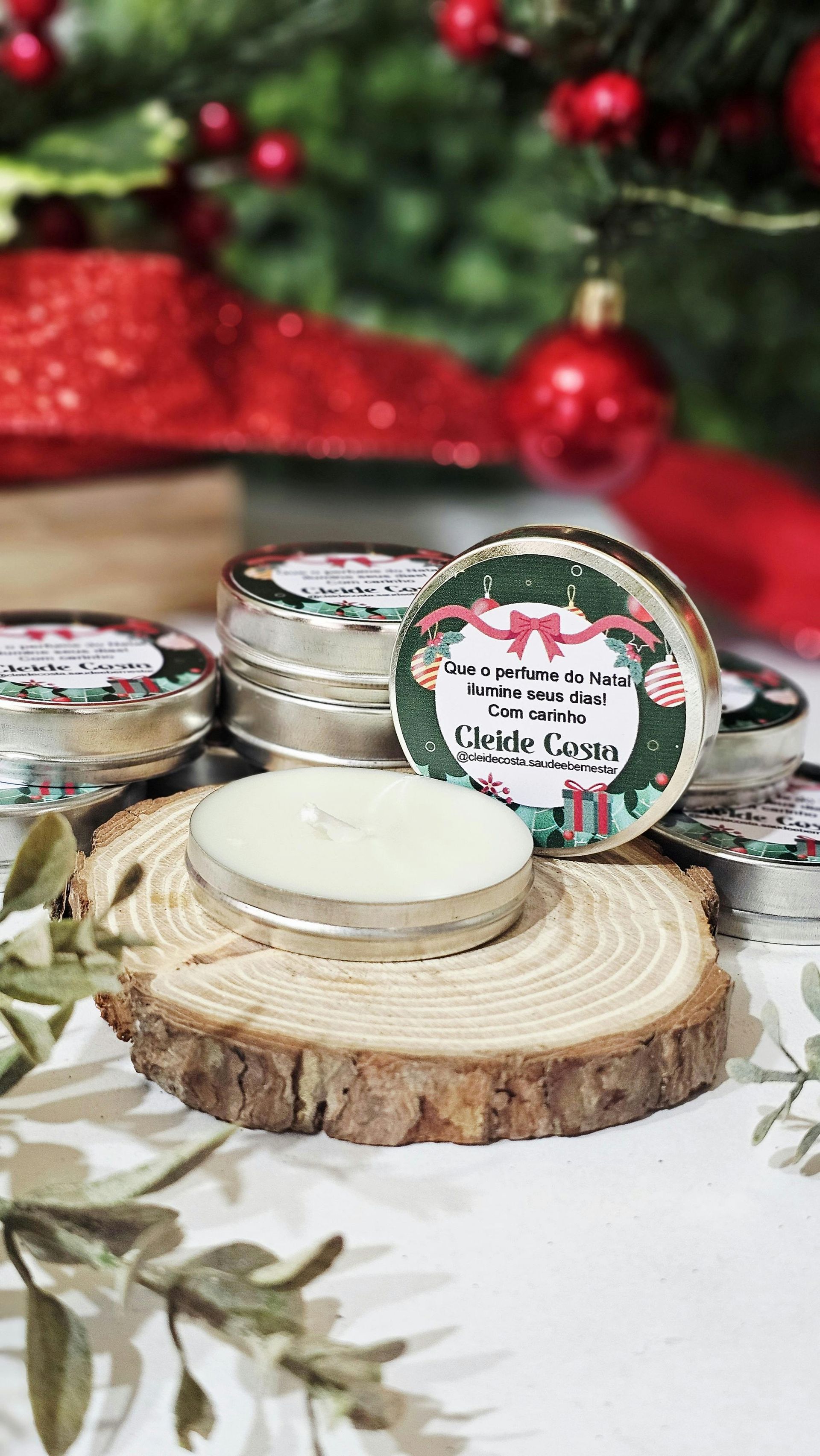 Tealight candle on wood slice with holiday-themed tins and Christmas decorations in background.