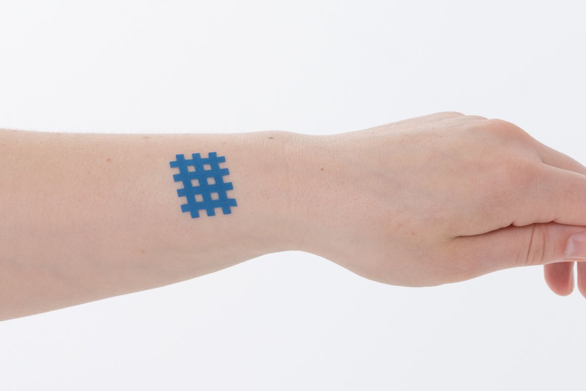 Un tatouage temporaire géométrique bleu sur le poignet d'une personne.