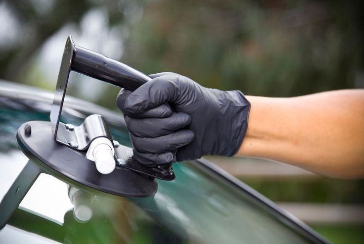 A man is working on the windshield of a car