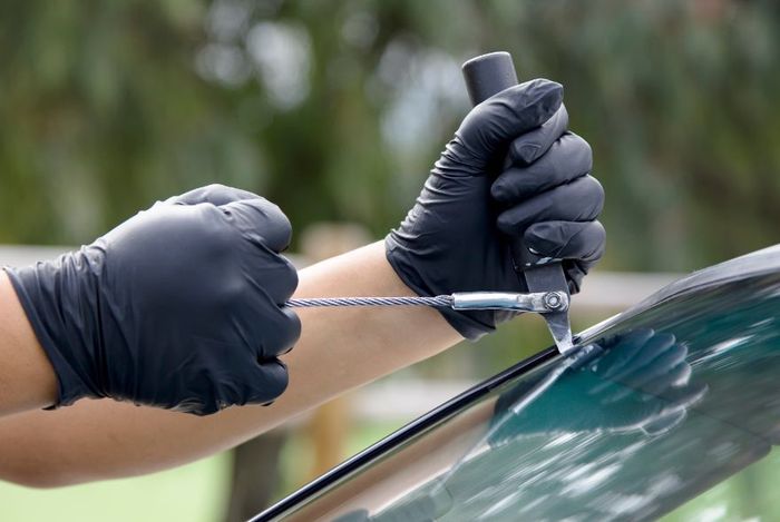 A man is installing a new windshield on a car.