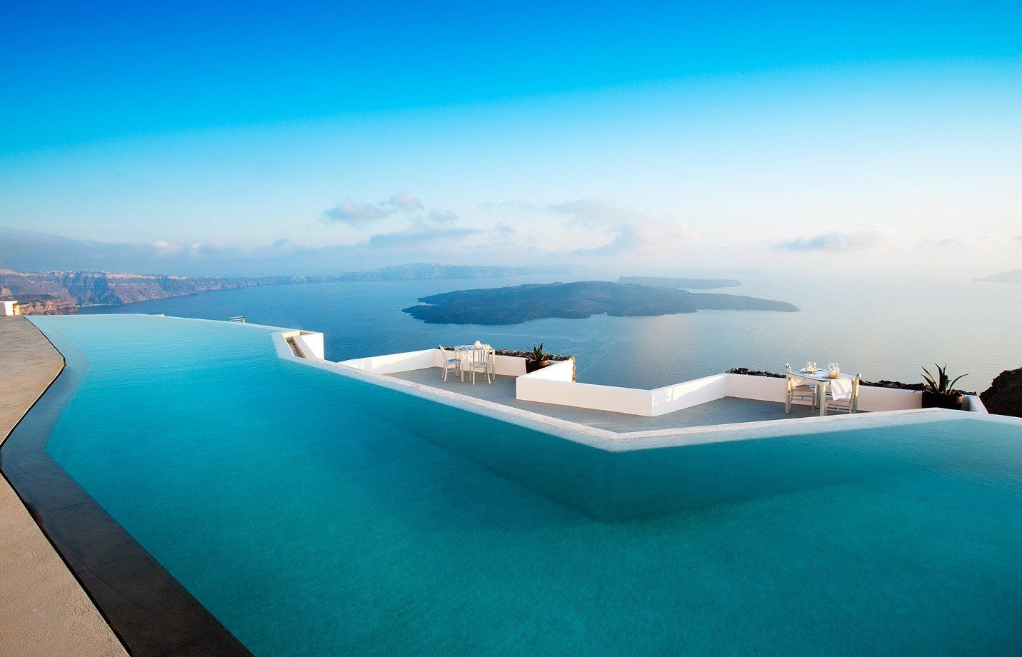 a beautiful infinity pool with a stunning oceanside backdrop