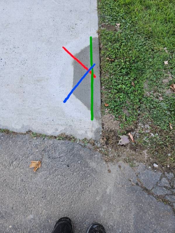 Concrete sidewalk with grass edge; colored lines show angles and a shadow.