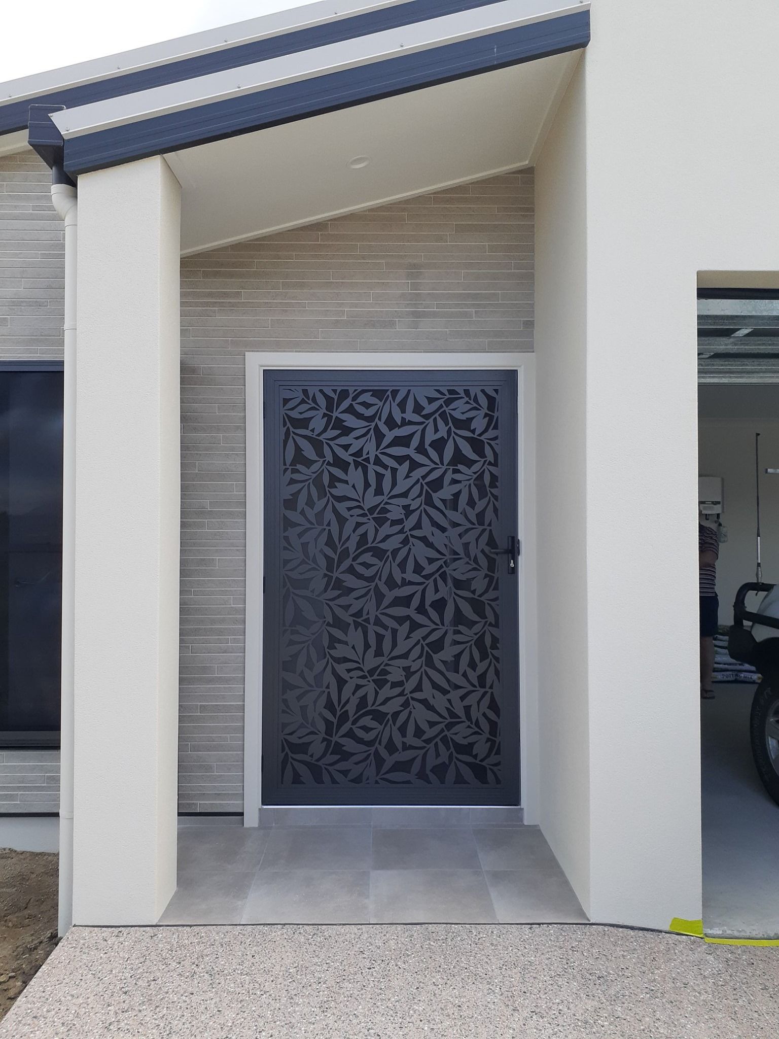 Dark gray patterned security door in a modern home entrance — A1 Security Screens Cairns In Smithfield, QLD