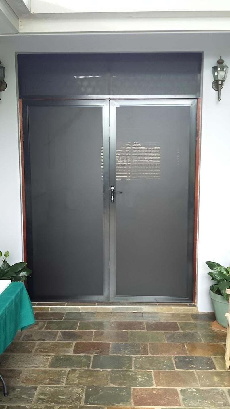 A Large Black Door is Sitting on Top of a Tiled Floor in a Room — A1 Security Screens Cairns In Palm Cove, QLD