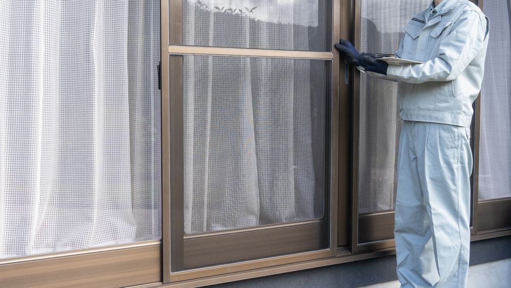 Person in Work Clothes Installing a Screen on a Window — A1 Security Screens Cairns In Redlynch, QLD