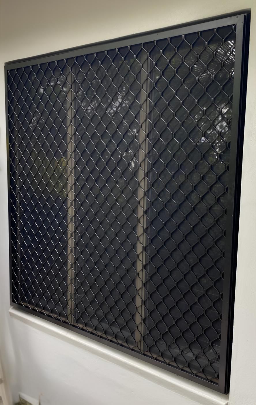 A Window With a Chain Link Fence on It is Hanging on a Wall — A1 Security Screens Cairns In Manunda, QLD