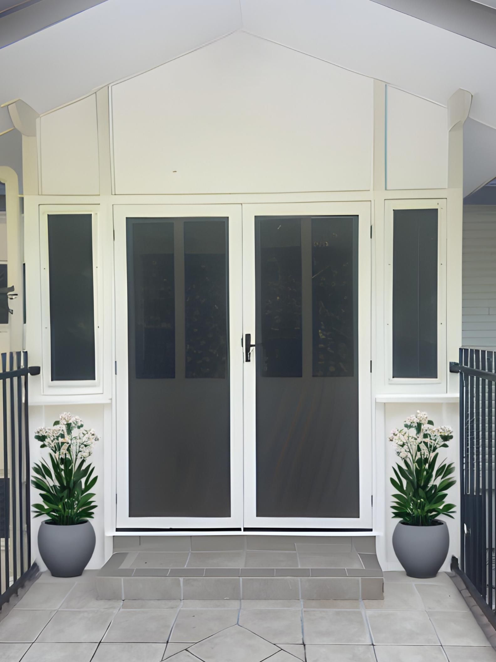 The Front Door of a House With Two Potted Plants in Front of It — A1 Security Screens Cairns In Palm Cove, QLD