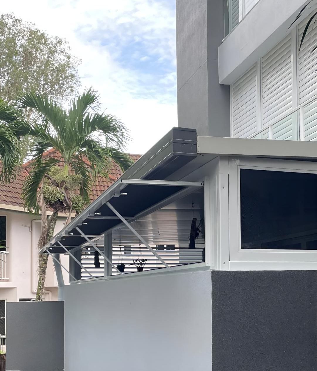 A Gray and White Building With a Black Awning Over a Window — A1 Security Screens Cairns In Edmonton, QLD