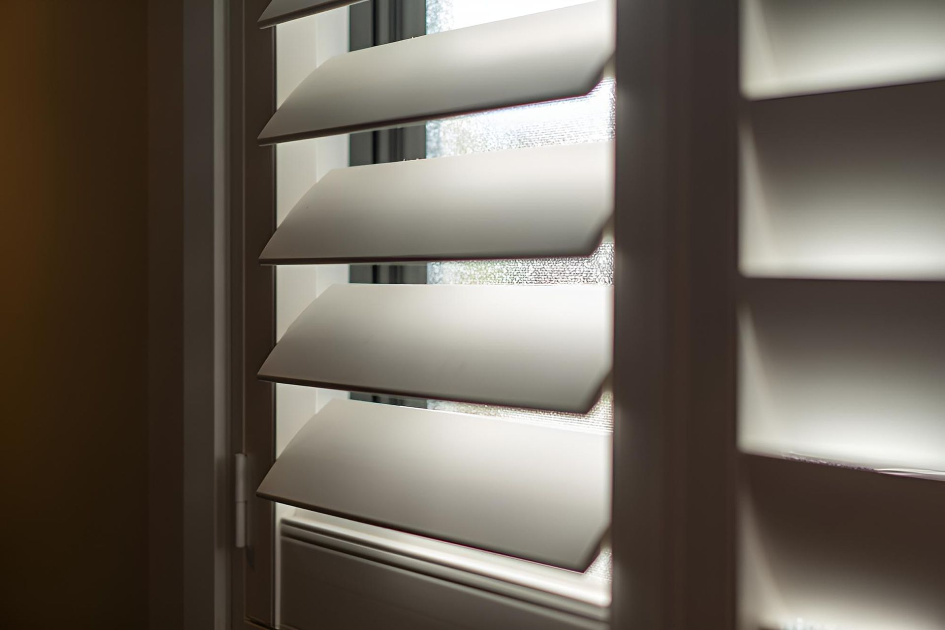 A Close Up of a Window With White Shutters on It — A1 Security Screens Cairns In Manunda, QLD