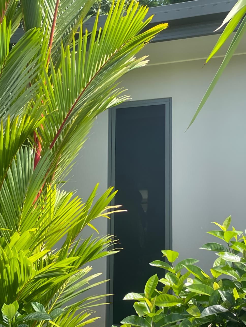A Mosquito Screen is Sitting on the Floor Next to a Window — A1 Security Screens Cairns In Palm Cove, QLD