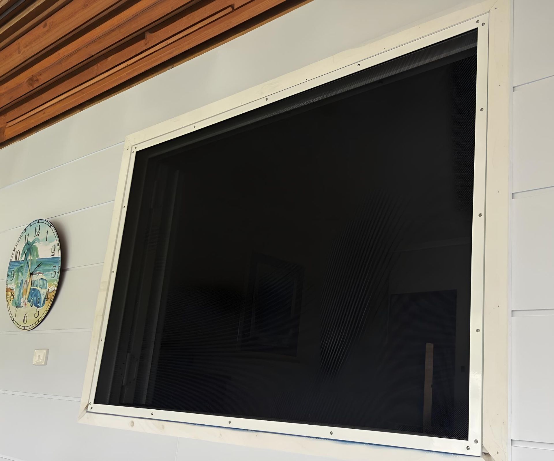 A Screened in Window With a Clock on the Wall Behind It — A1 Security Screens Cairns In Manunda, QLD