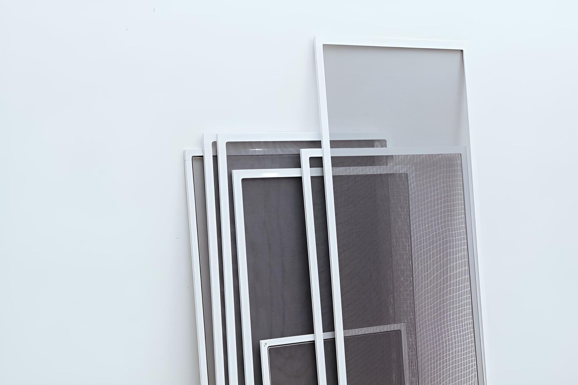 A Stack of Mosquito Screens Sitting on Top of Each Other on a White Surface — A1 Security Screens Cairns In Manunda, QLD
