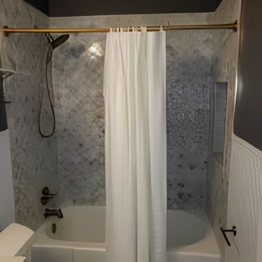 Bathroom with bathtub, showerhead, and white curtain in a gray tiled alcove.