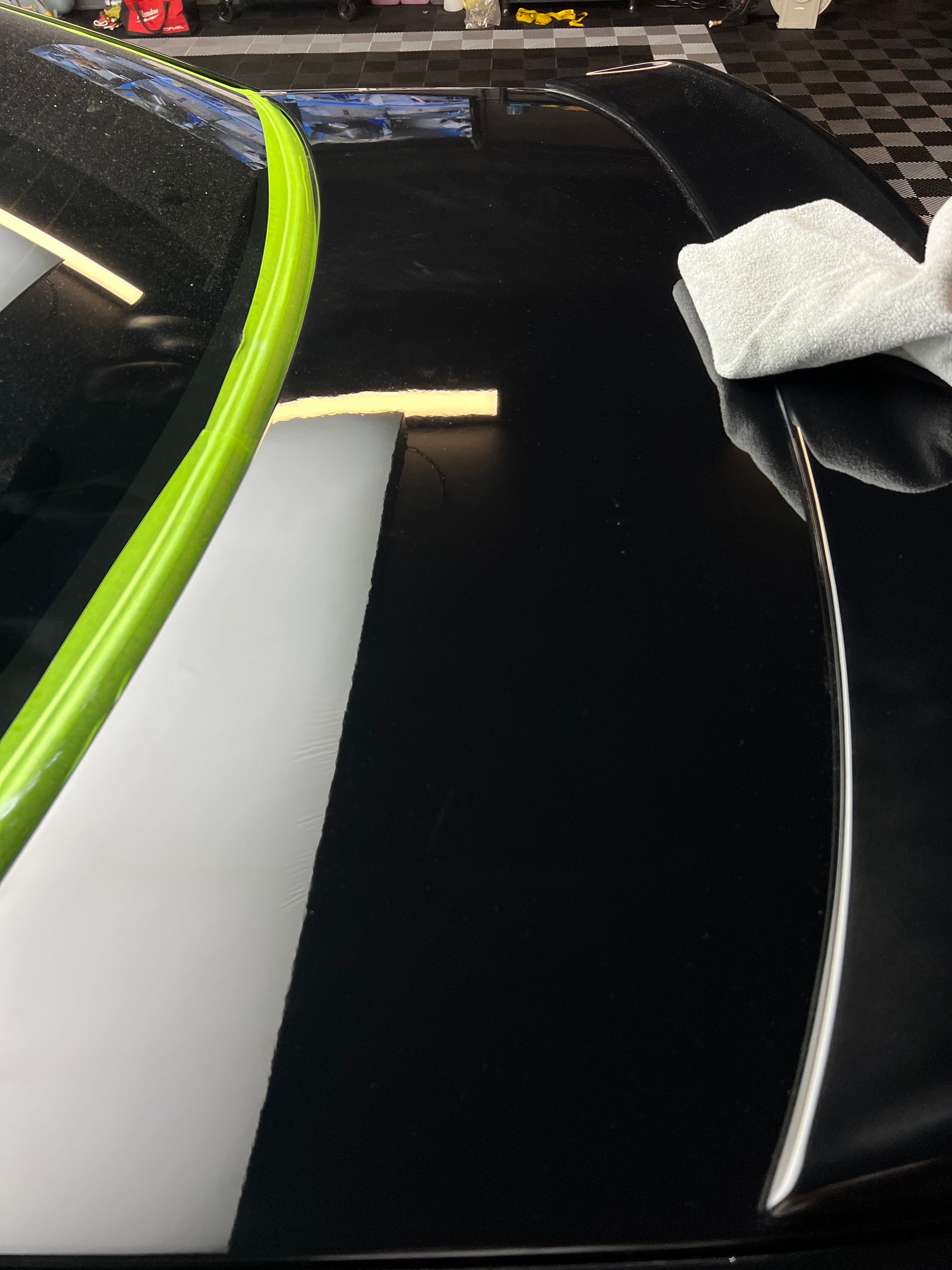 A black and white car with a green stripe on the hood