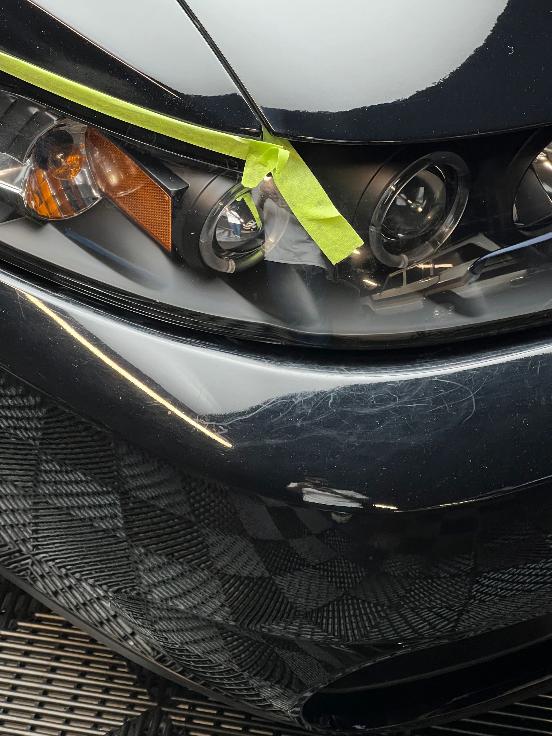 A close up of a car headlight with yellow tape on it