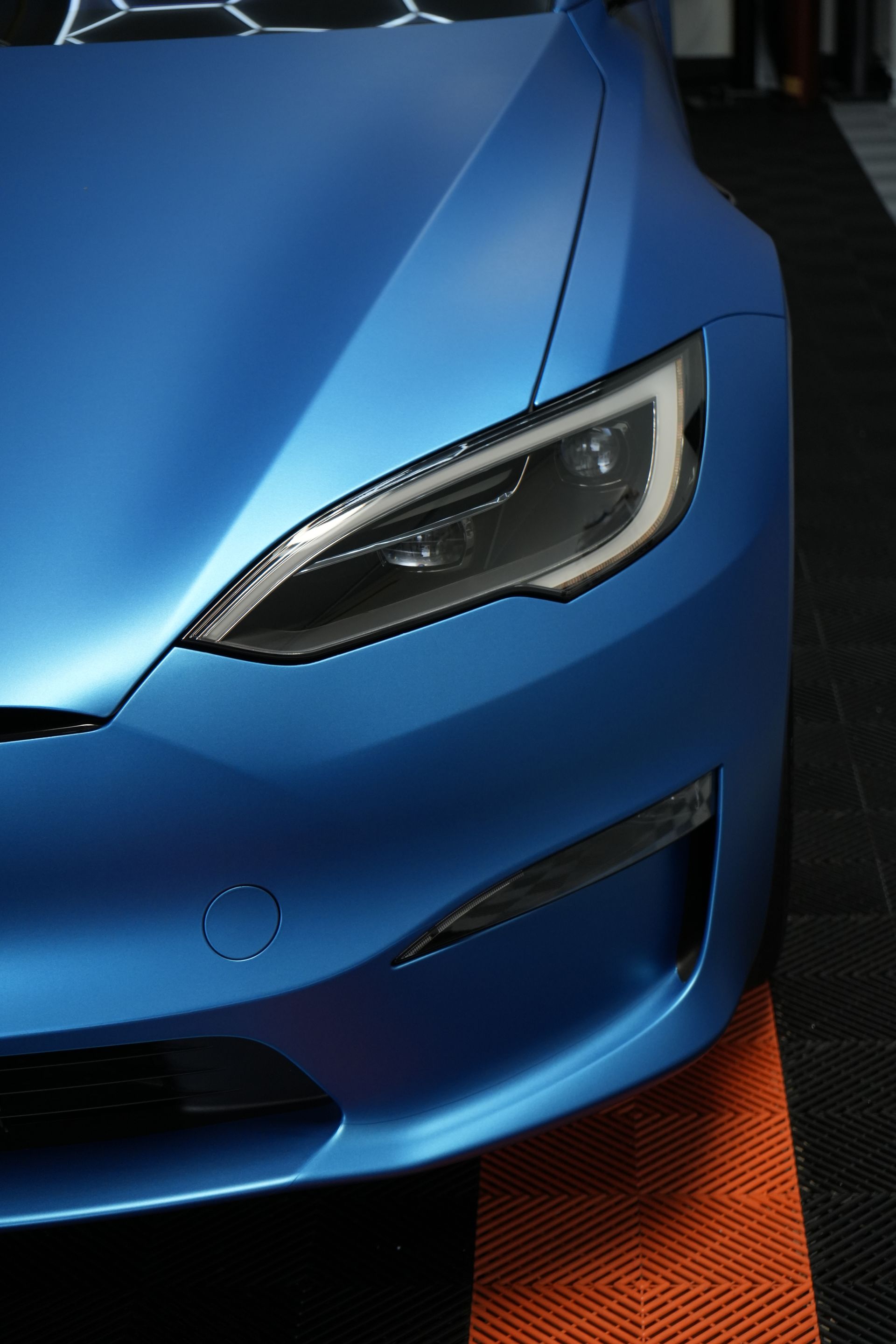 A close up of the front of a blue tesla model s