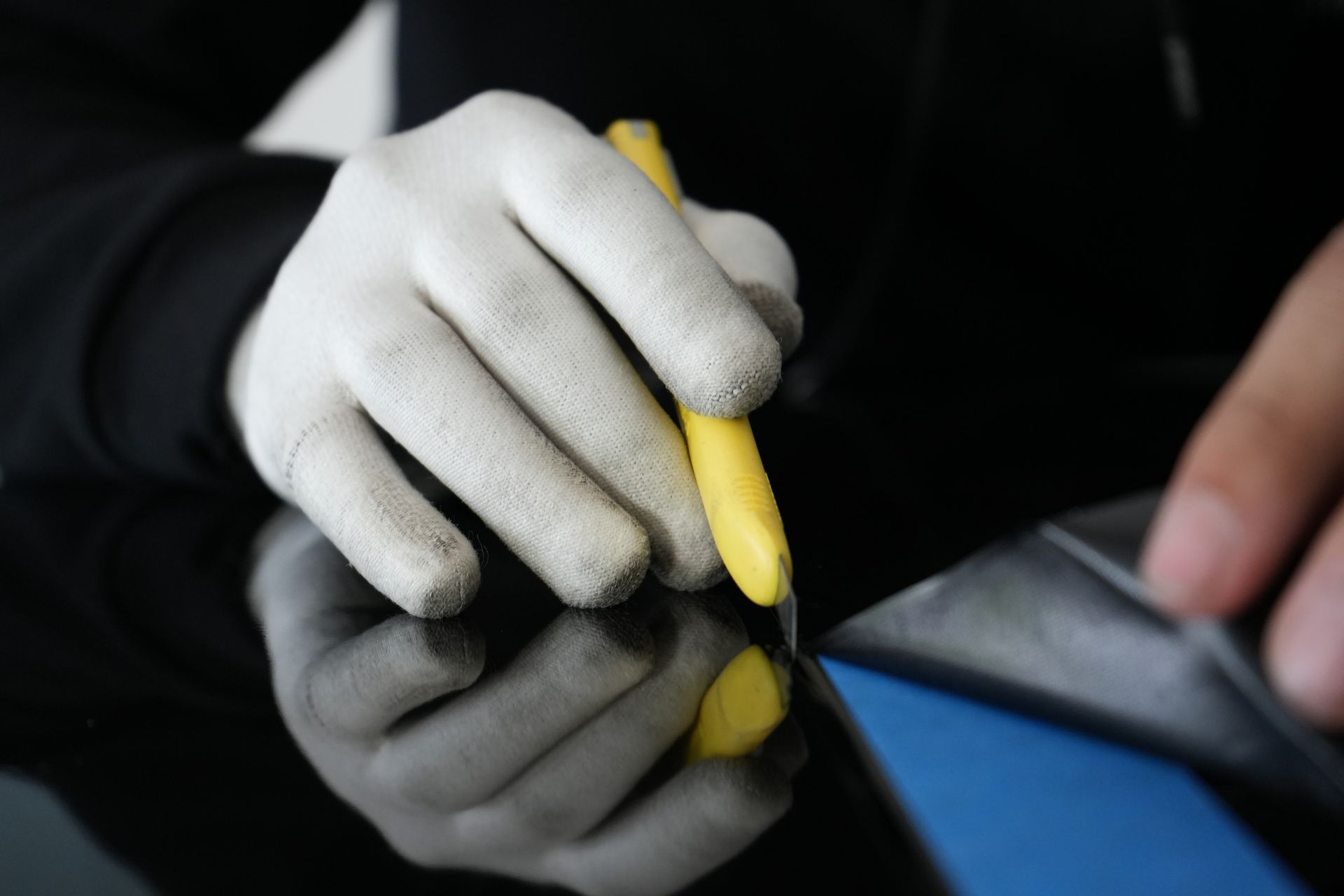 A person wearing gloves is holding a yellow marker