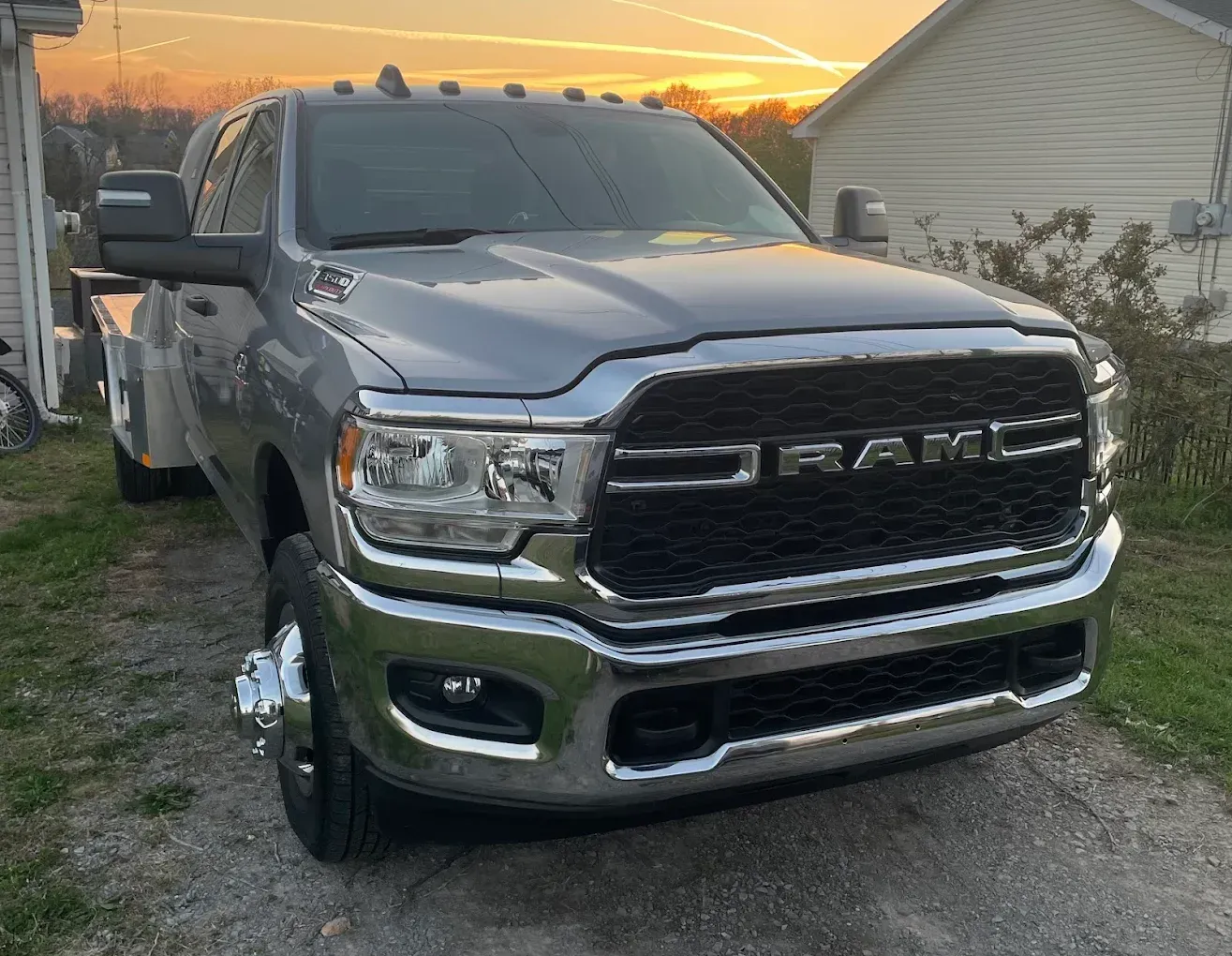 Gray RAM pickup truck parked in a driveway at sunset