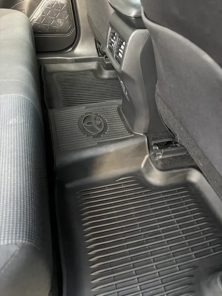 Car floor mat and rear seat footwell, black rubber with ridged texture and Toyota logo