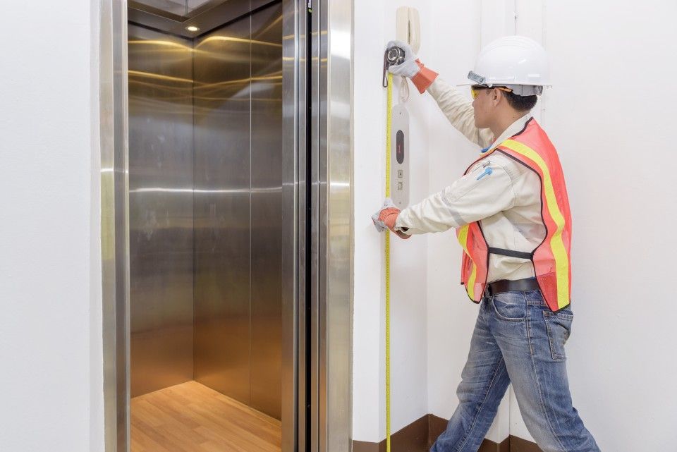 worker taking measurements of the elevator
