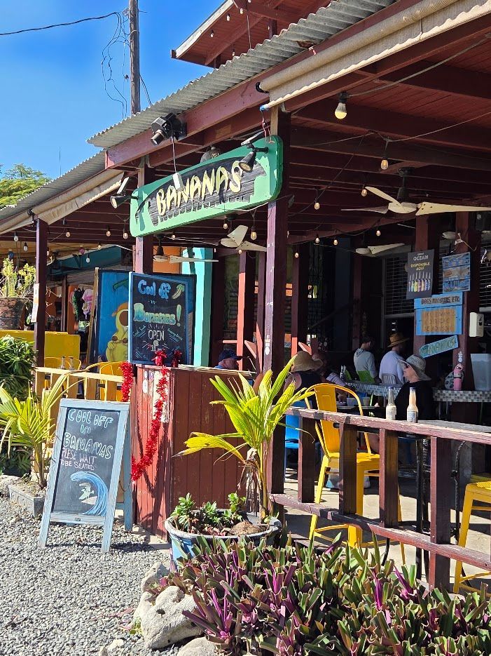 Plate of seafood: lobster, shrimp, scallops, broccoli, tomatoes, with white wine and a menu.
