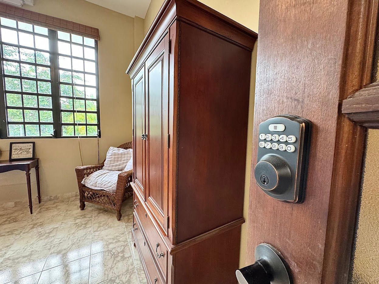 Wooden wardrobe in a room with a window and a digital door lock.