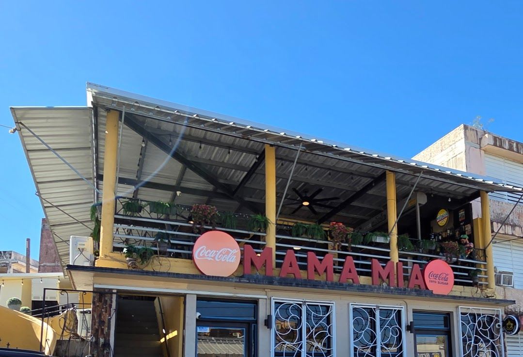 Grilled steak with fries, fish and chips, lemon, sauce, and a pint of beer on a table in a pub.