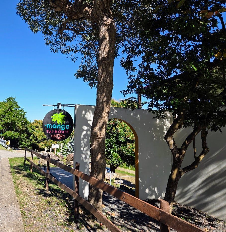 Beer flight with various brews next to a plate of churros on a wooden table.
