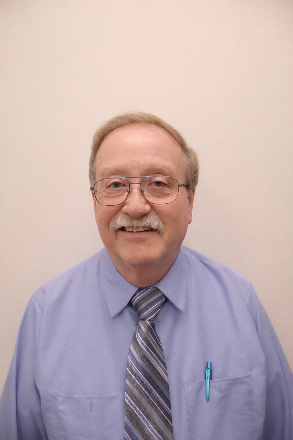 Woman in a white lab coat smiling, with