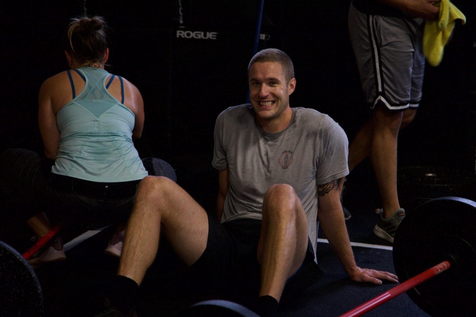 A man and a woman are sitting on a bench in a gym.