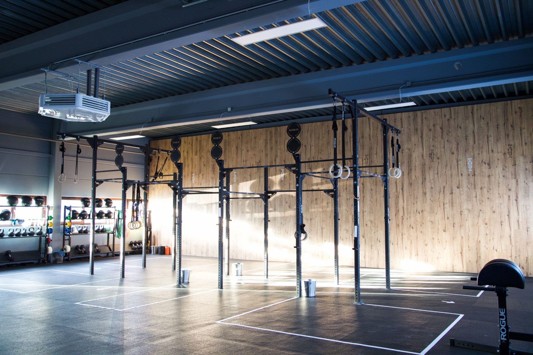 Eine große, leere Turnhalle mit einer Holzwand und einem Holzboden.