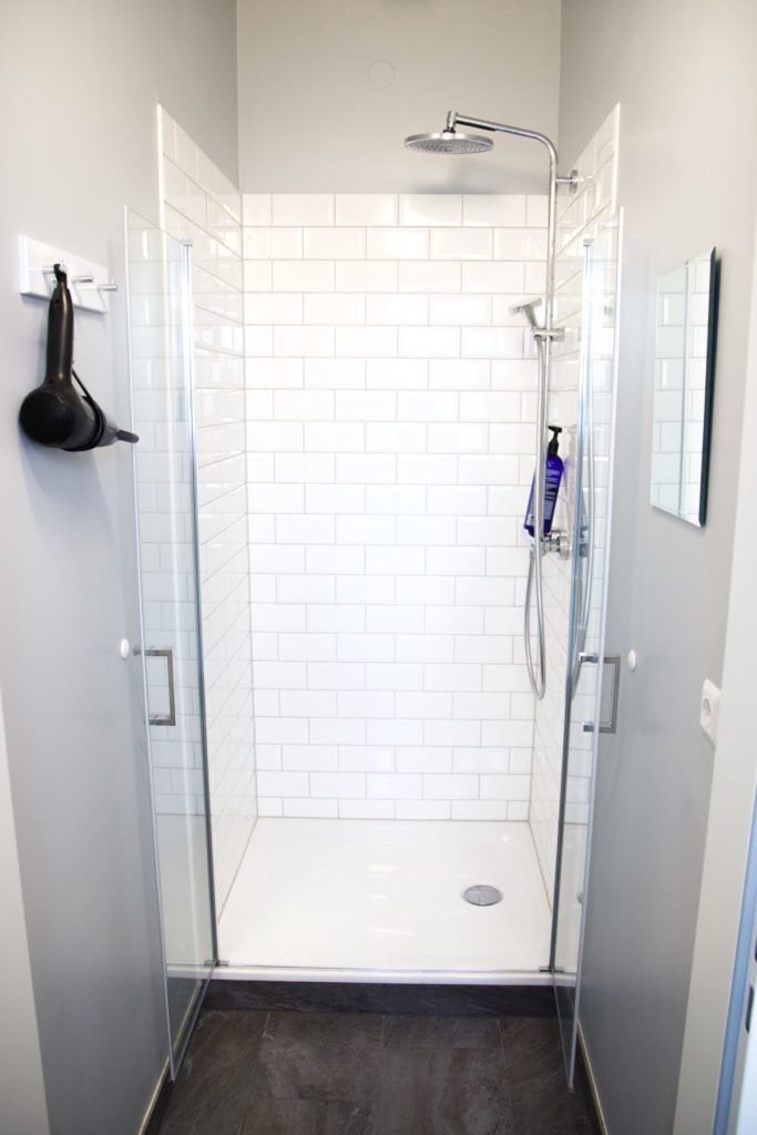 Ein Badezimmer mit ebenerdiger Dusche und Spiegel.