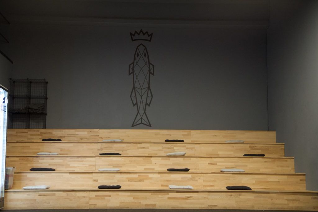 Eine Holztreppe mit einer Fischzeichnung an der Wand.