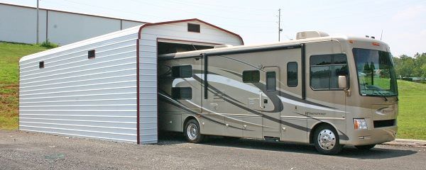 A large rv is parked in front of a garage