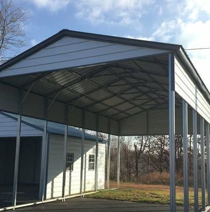 A beautiful red custom metal barn with a gambrel roof and a weathervane on a sunny day.