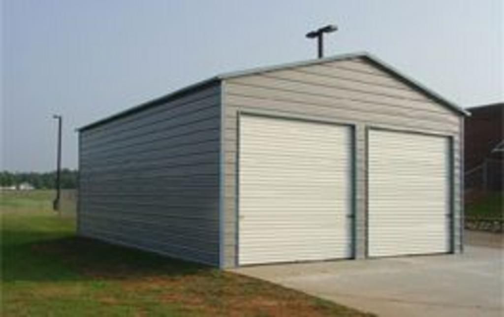 A metal garage with two garage doors and a light on top of it.