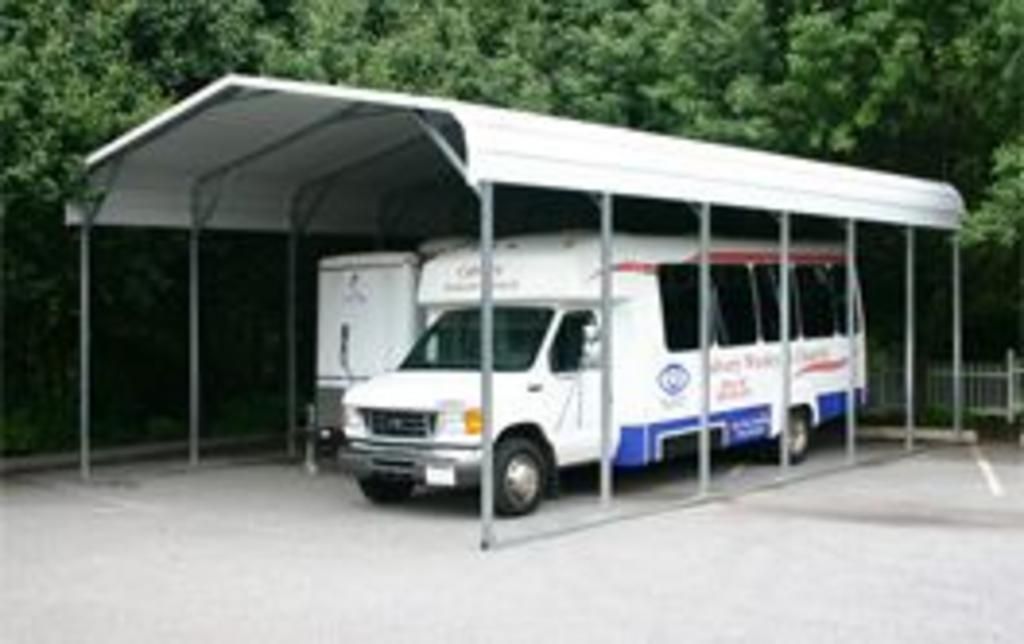 A white van is parked under a white canopy