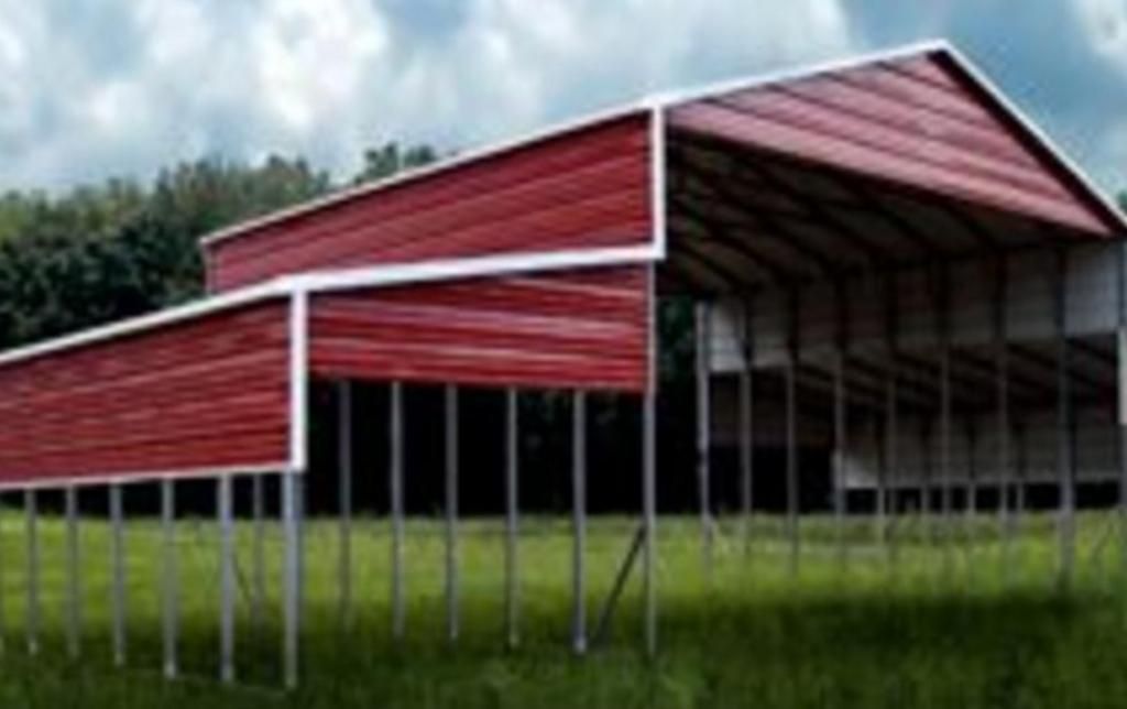 A red barn is sitting in the middle of a grassy field.